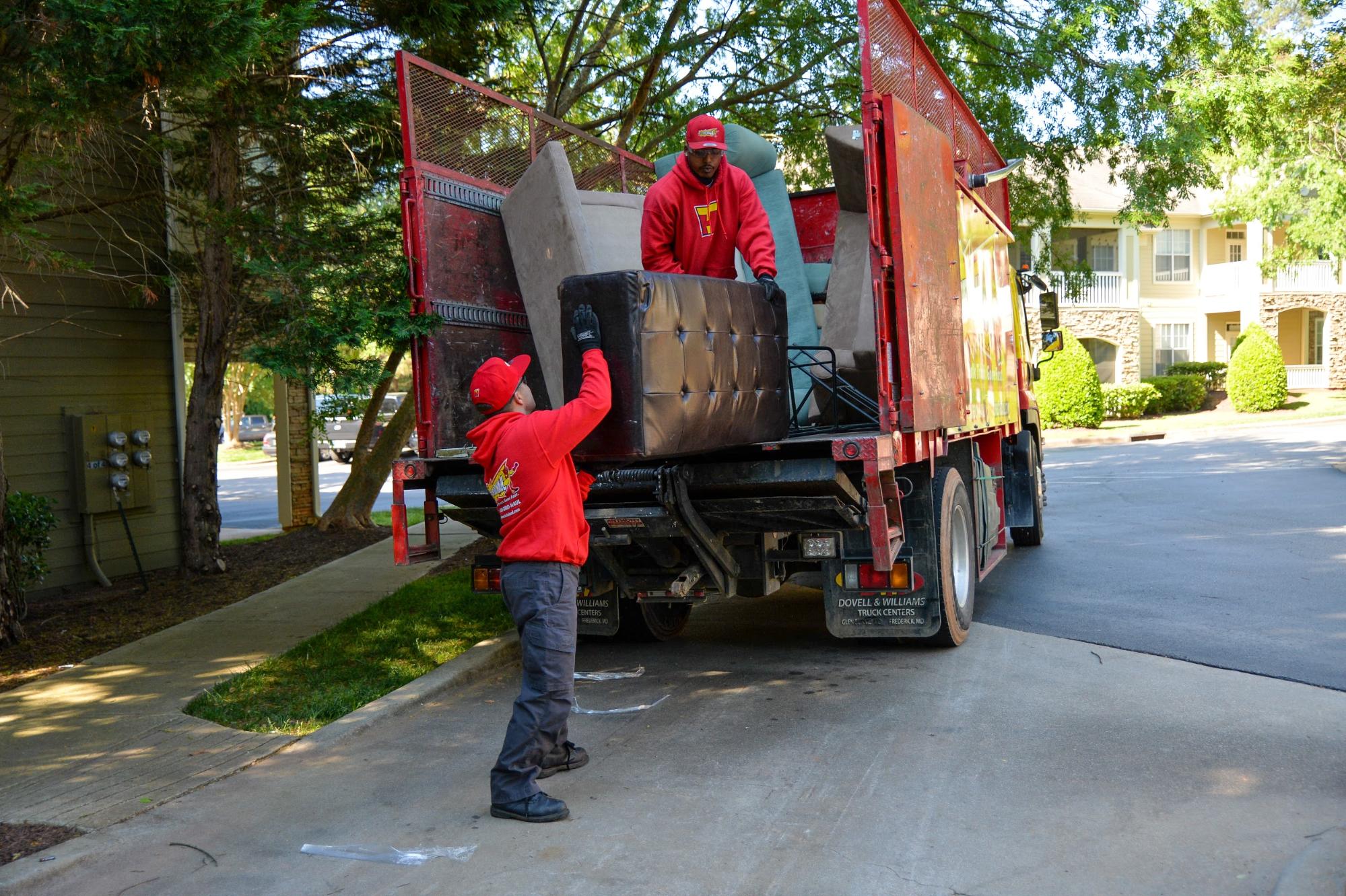 Raleigh North Carolina junk removal crew members load furniture onto their hauling truck