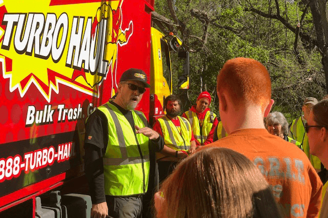 Turbohaul's CEO chats with employees and Clarksburg, MD residents by his big red junk removal service truck.