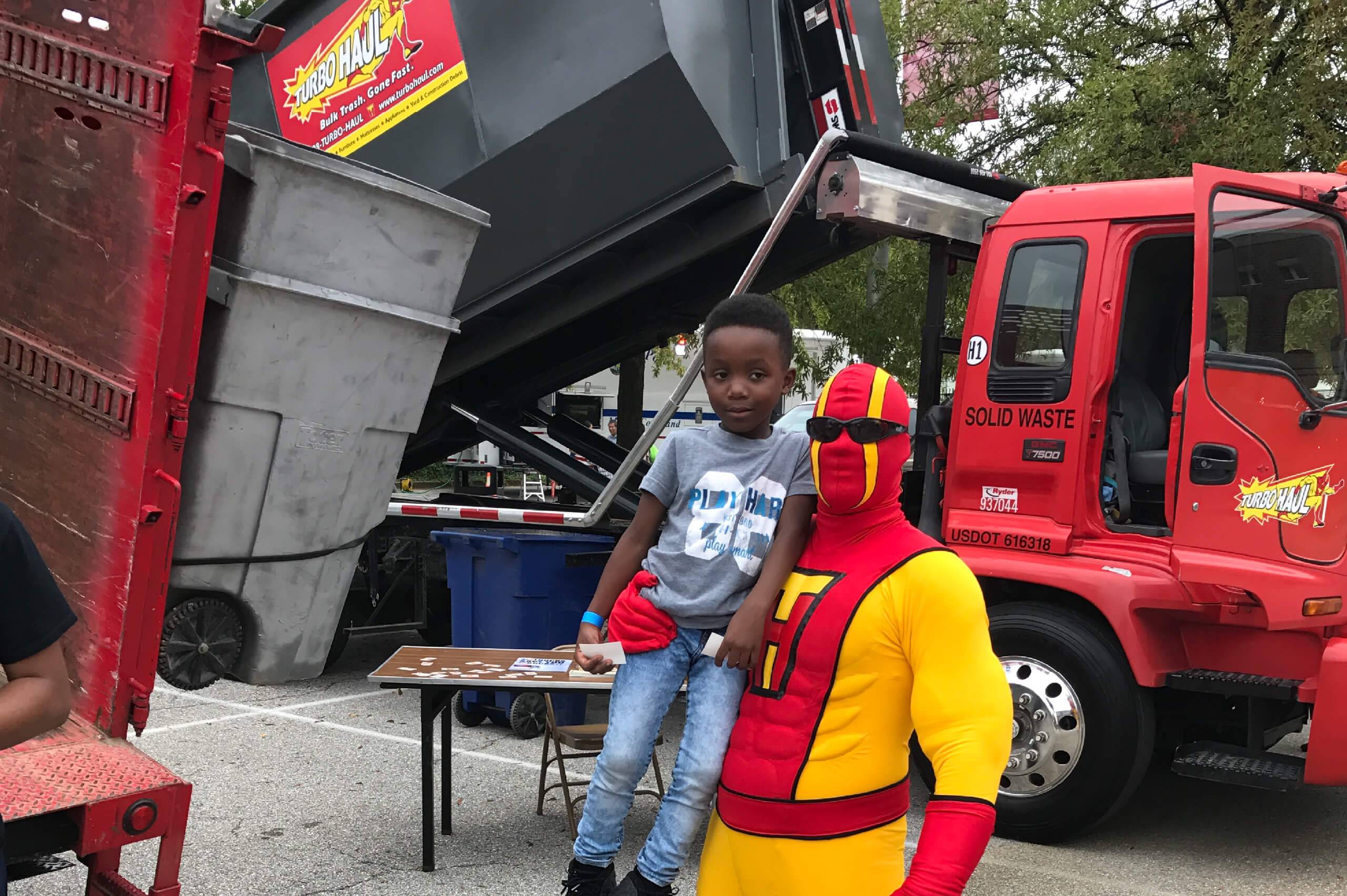 TurboMan poses with young Germantown, Maryland residents during a bulk trash hauling and junk removal event.