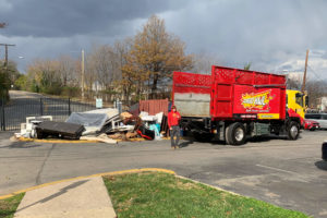 A TurboHaul employee walks from their big red junk hauling and bulk trash removal trucks in Annapolis, Maryland.