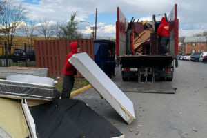 A hardworking junk removal specialist from TurboHaul moves a mattress in Fairfax, Virginia.