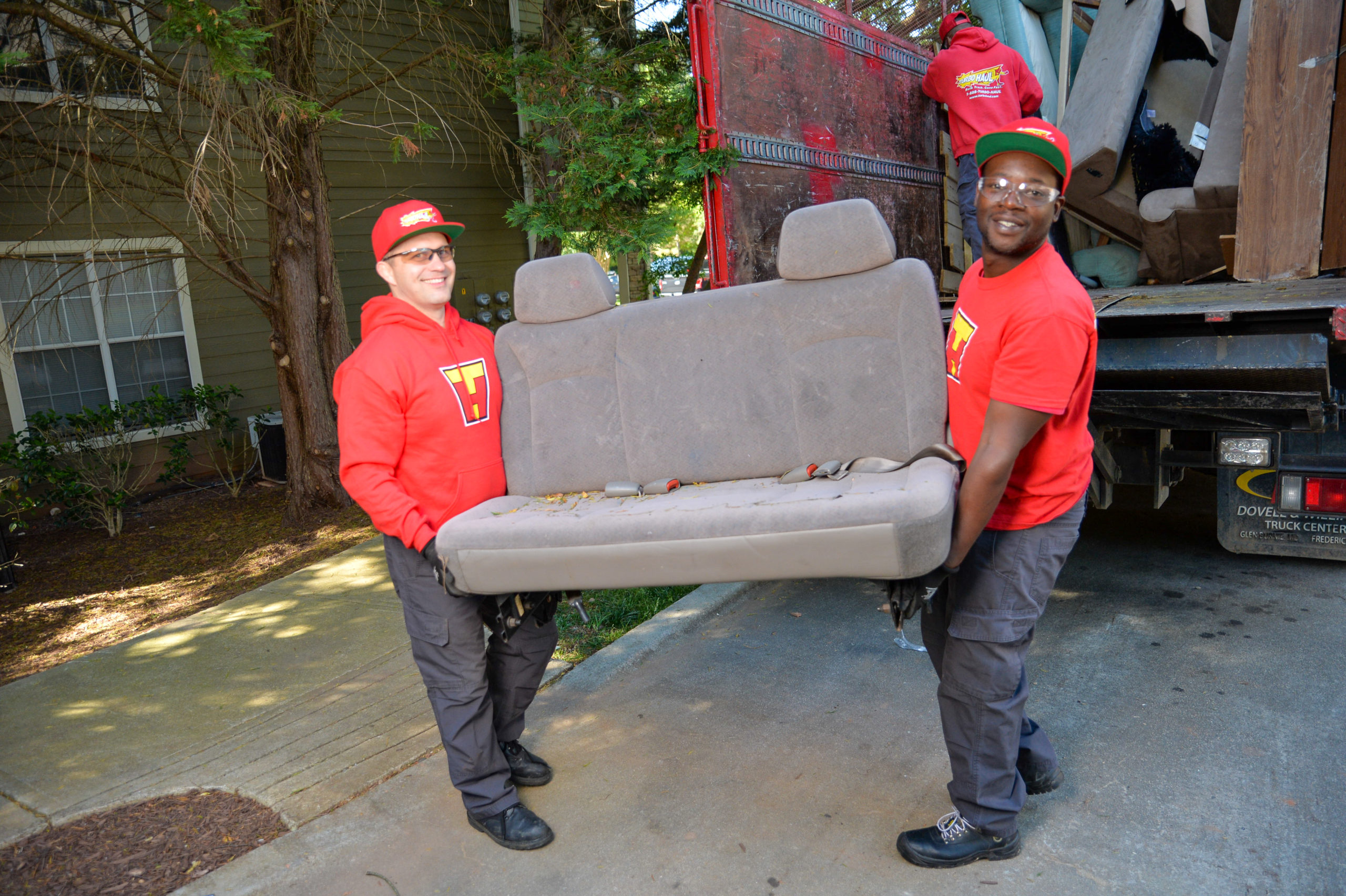 Two TurboHaul employees move a couch during a junk removal and bulk trash hauling job in Montgomery Village, Maryland.