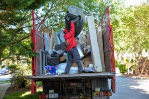 A TurboHaul employee dumps trash into their big red junk hauling and bulk trash removal trucks in McLean, Virginia.