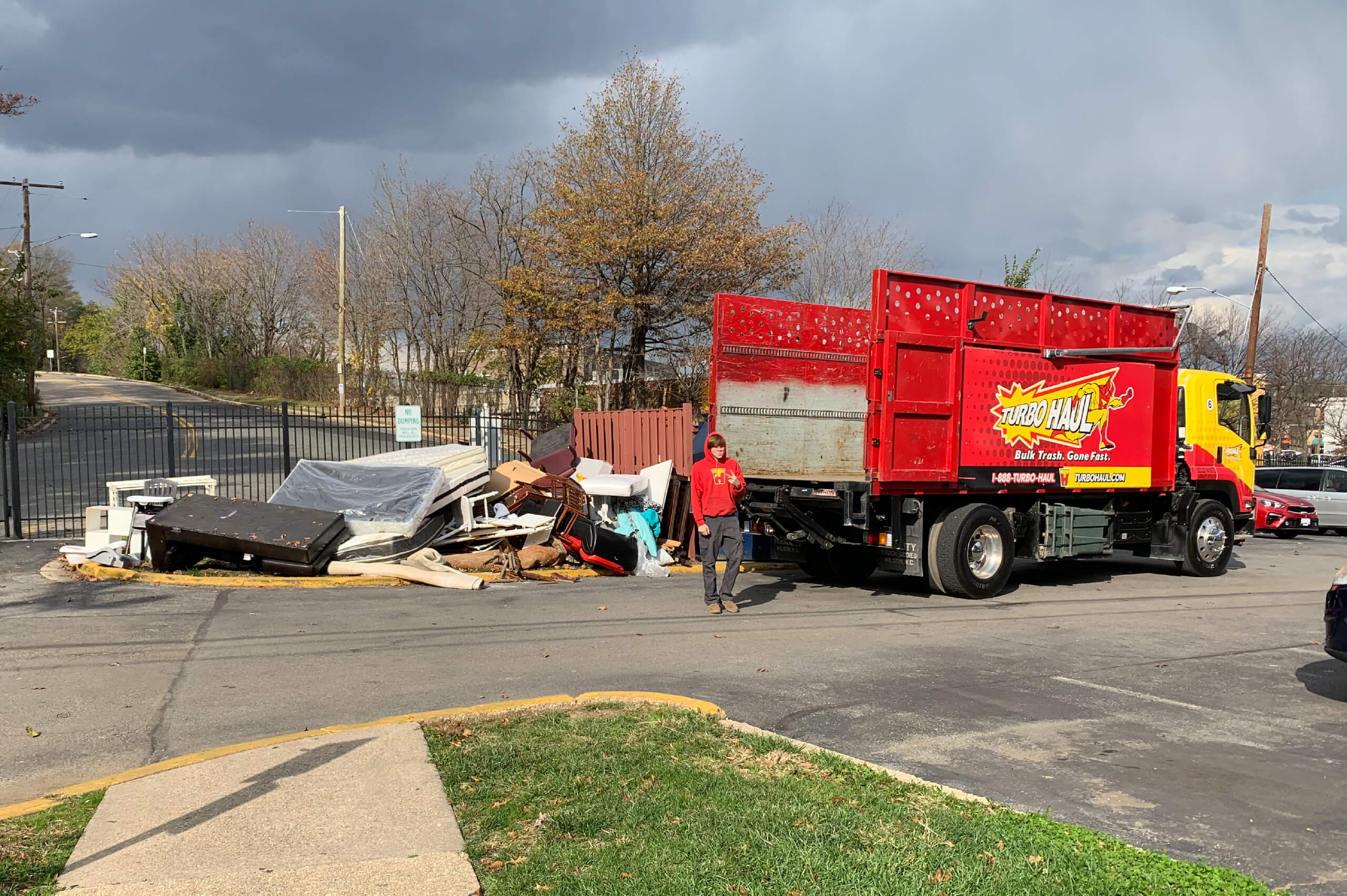 A TurboHaul employee walks from their big red junk hauling and bulk trash removal trucks in Chevy Chase, Maryland.