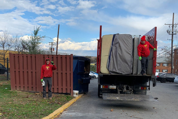 Two TurboHaul employees haul junk and remove mattresses during a Falls Church, Virginia job.