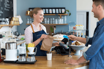 Coffee shop worker handing bag to customer
