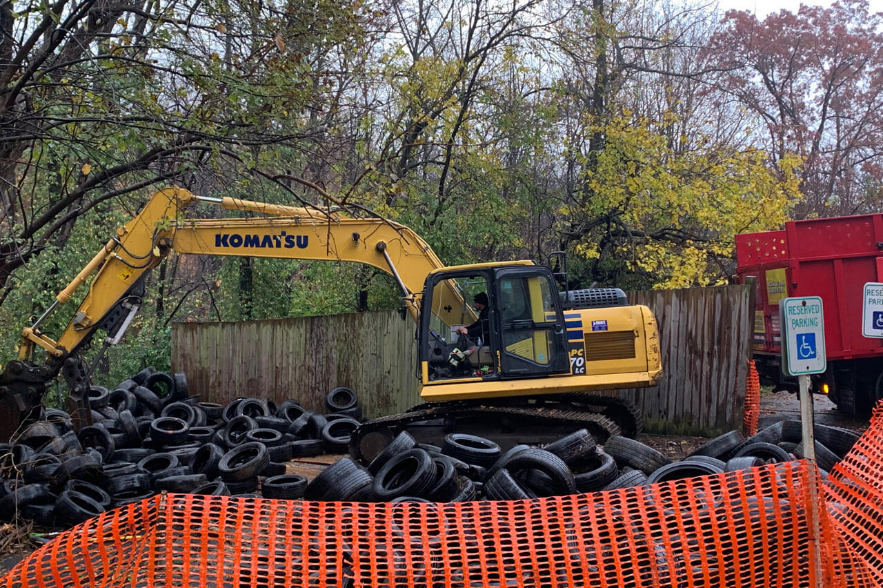 Machinery hauls tires from a lot during a bulk trash removal job in New Carrollton, MD.