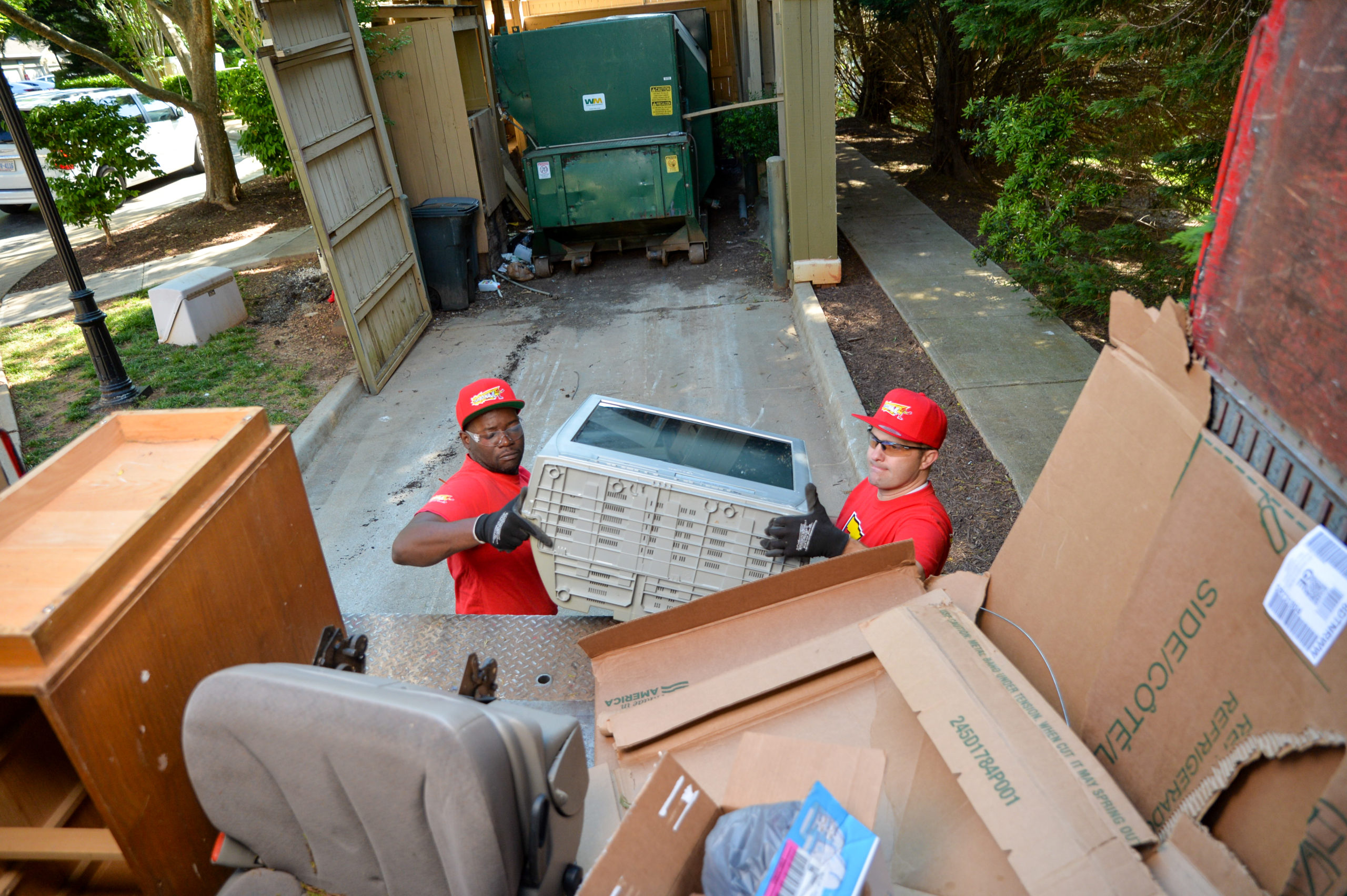 Two TurboHaul employees haul junk and remove trash during a Catonsville, Maryland job.