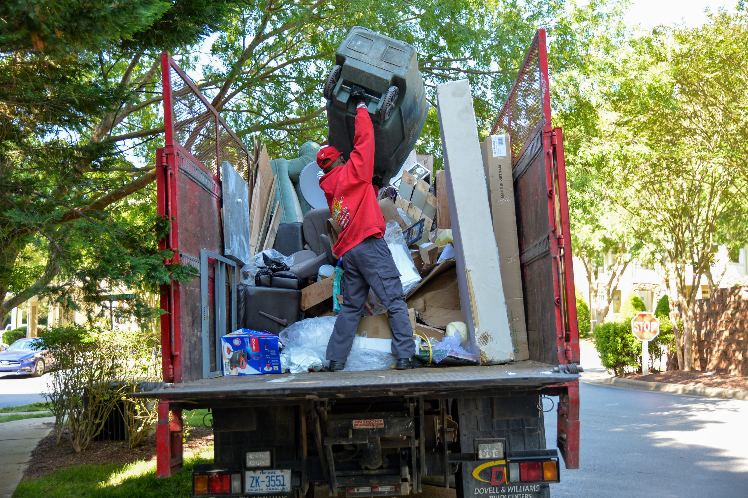 A TurboHaul employees load junk into their truck during a bulk trash removal job in Elkridge, MD.