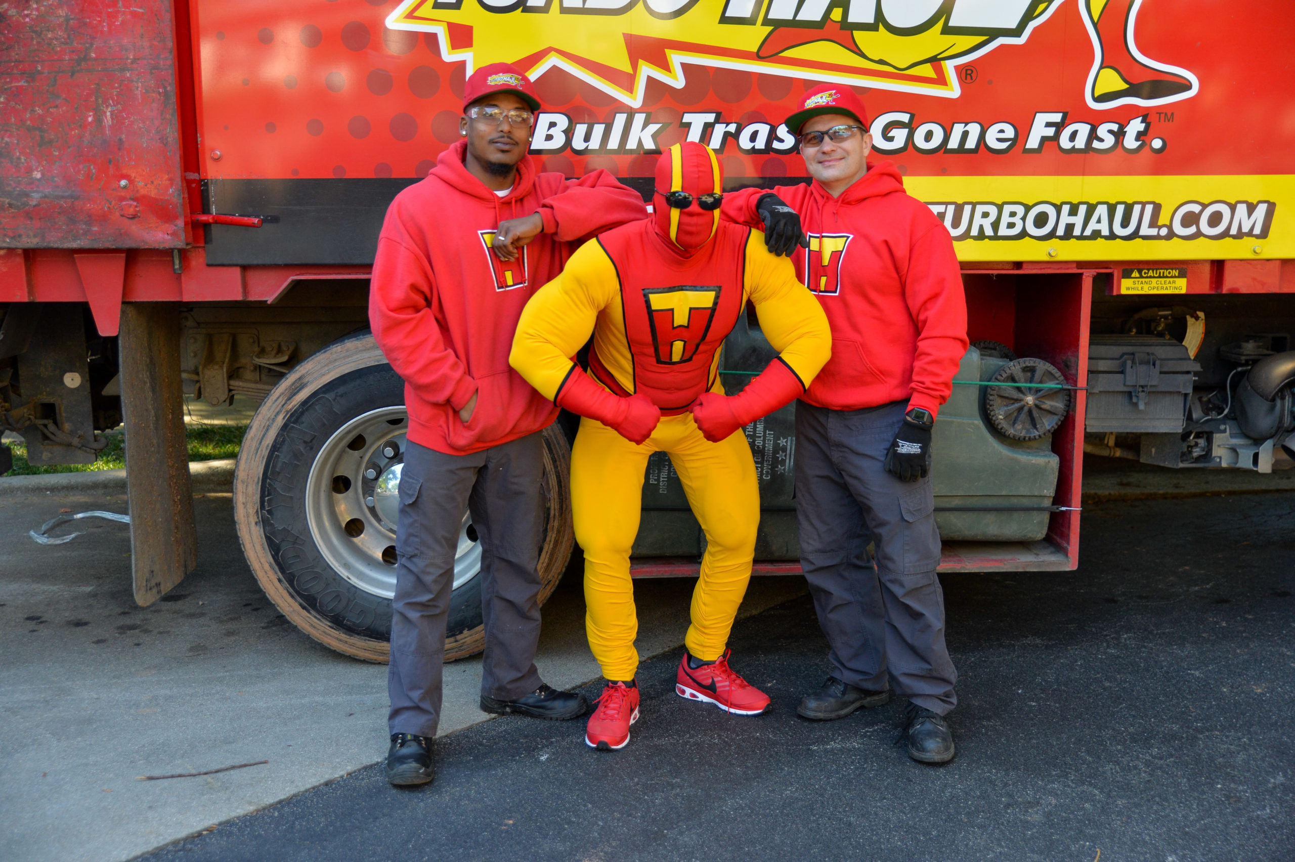 TurboMan poses with two employees during a bulk trash hauling and junk removal service job.
