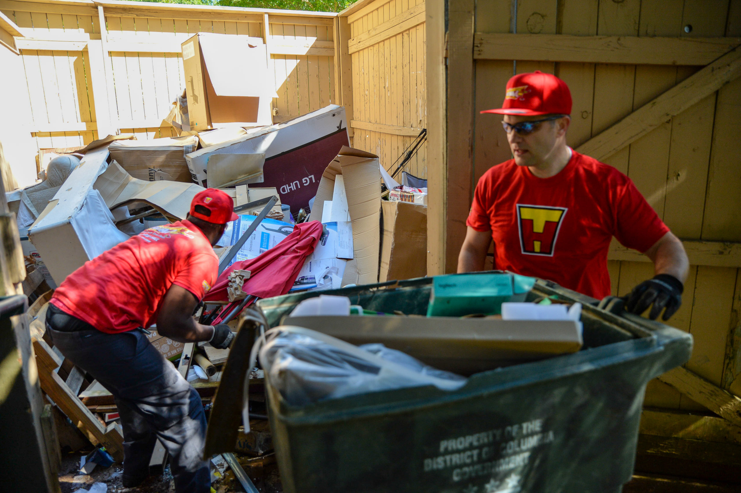 Two TurboHaul employees haul junk and remove trash during a Forest Heights, Maryland job.