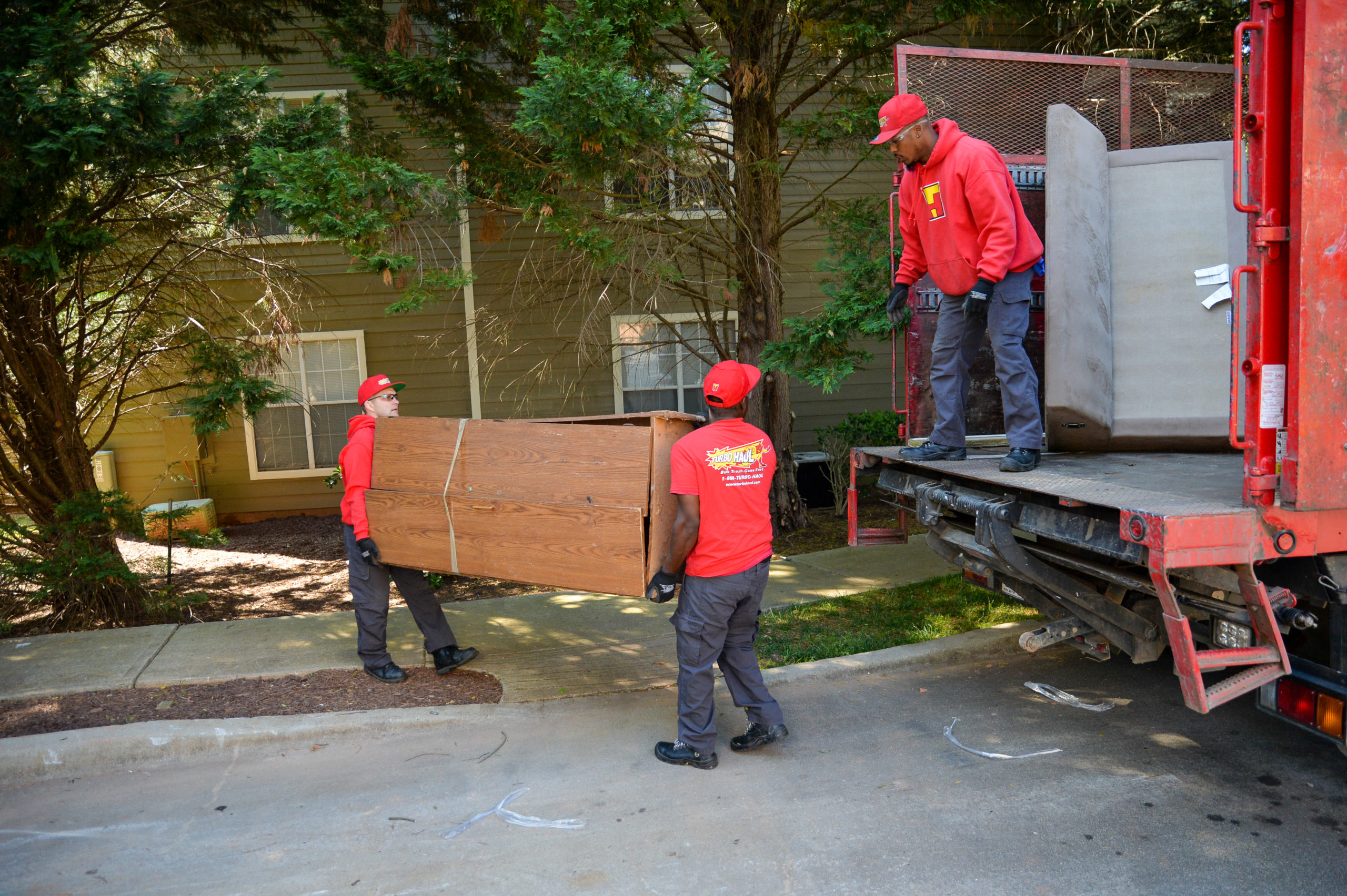 Three Damascus, MD employees loading bulk trash into a truck