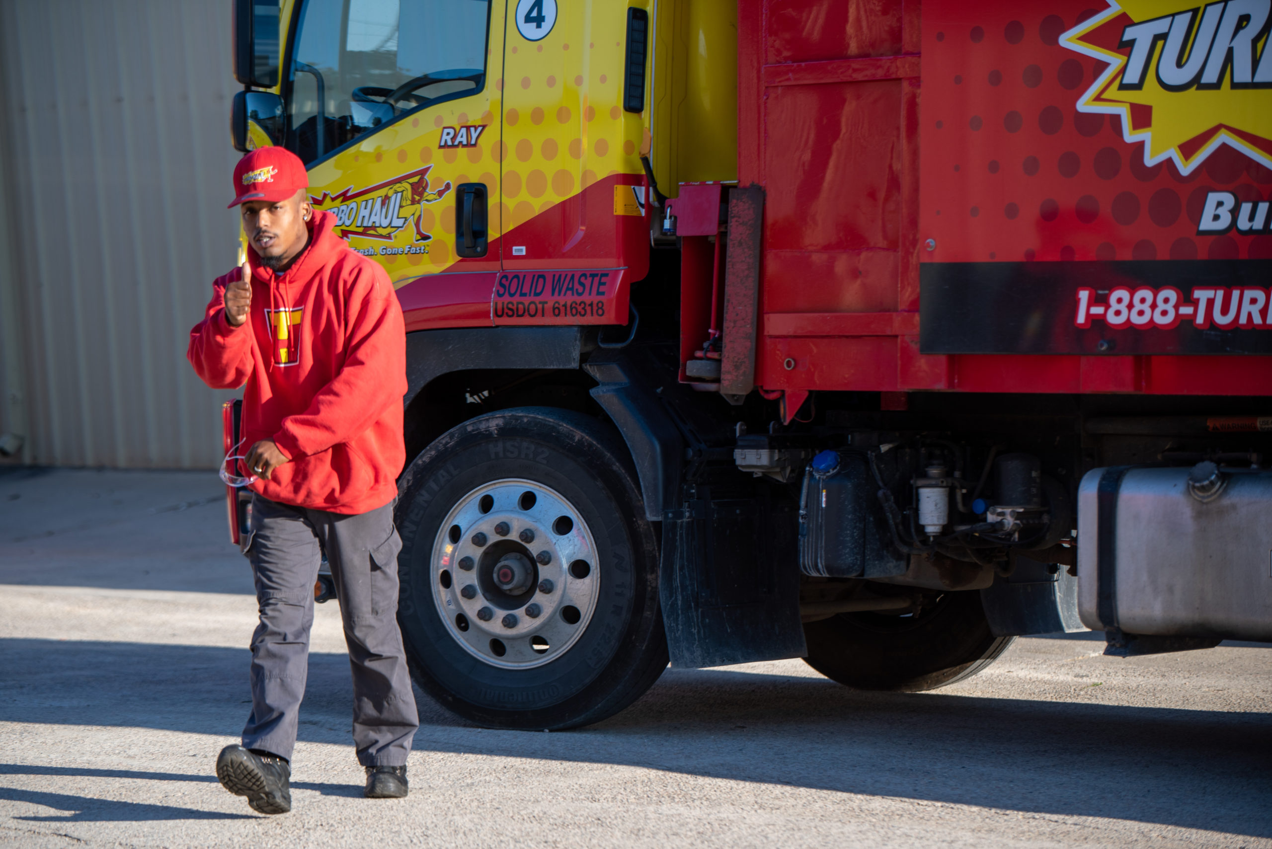 A Cooksville junk removal specialist walks away from the TurboHaul truck while giving the thumbs-up sign.