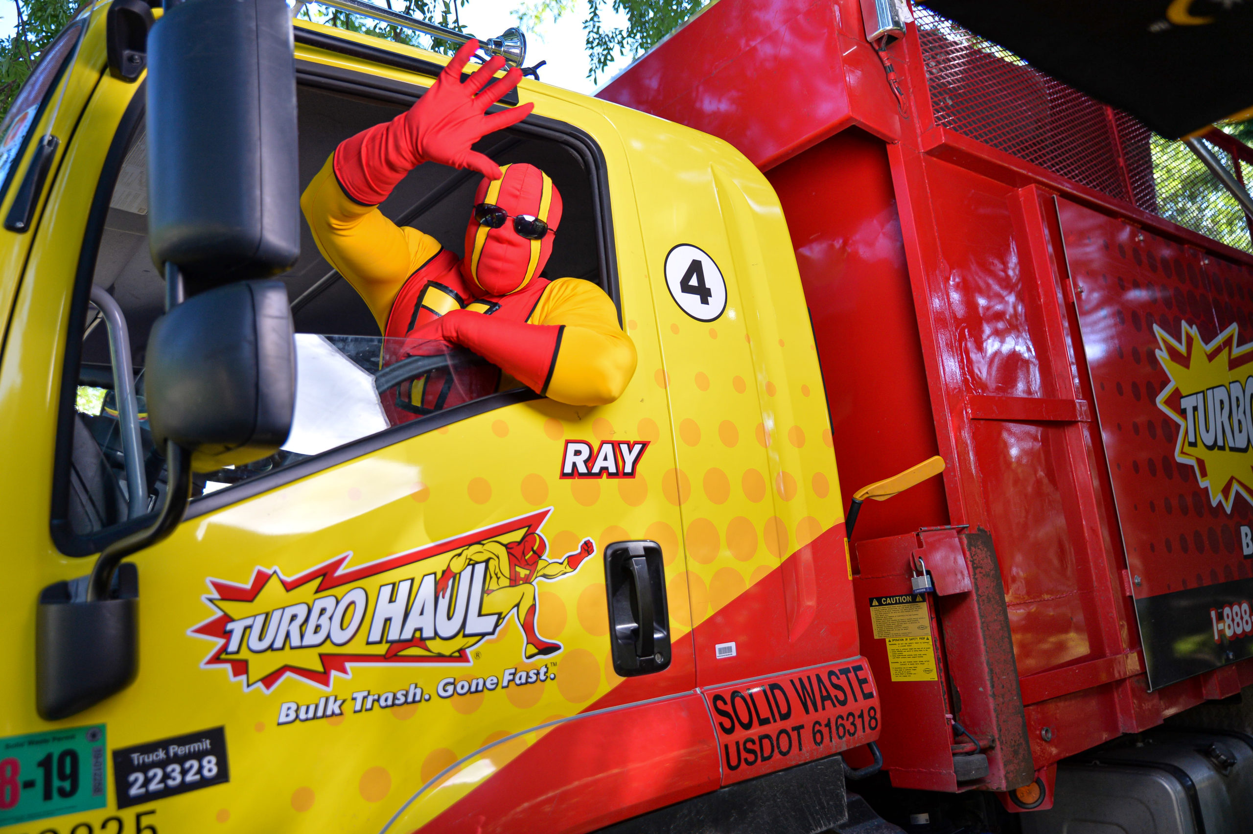 TurboHaul Man waves from the front seat of a truck in Linthicum, Maryland